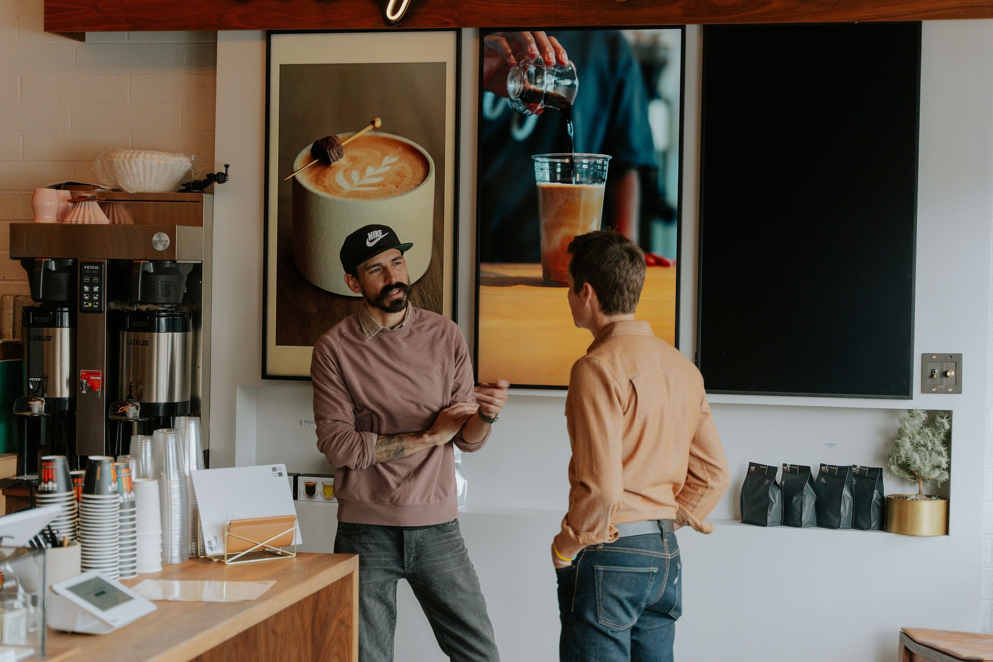 Two baristas talking behind the coffee bar at Case Study